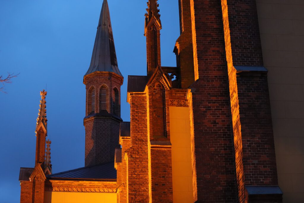Türme der Heilig-Geist-Kirche in Werder (Havel) bei abendlicher Beleuchtung.