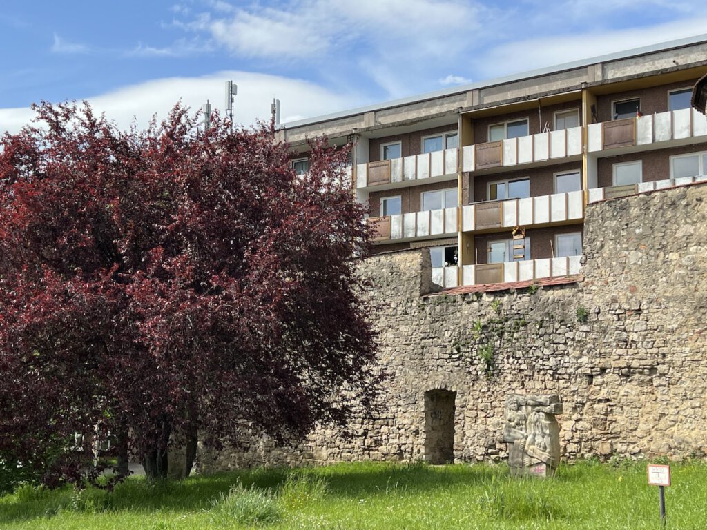 Stadtmauer von Gera mit Balkonen eines Plattenbaus im Hintergrund