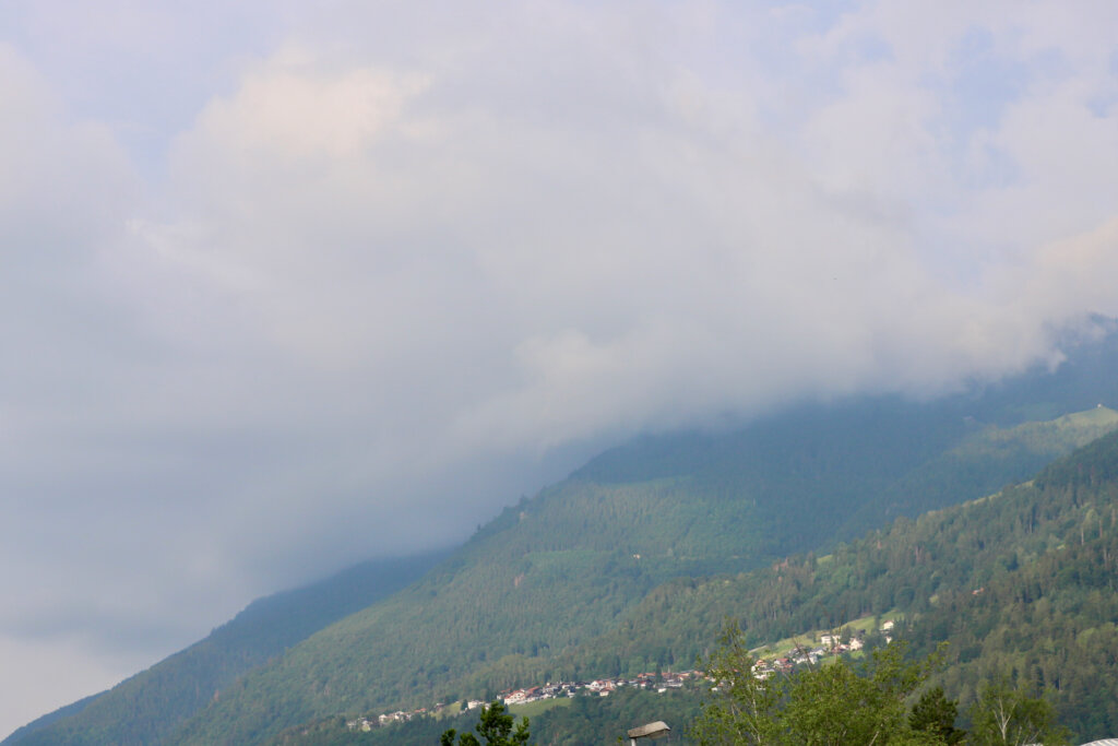 Wolken schieben sich über die Alpen im Fürstentum Liechtenstein. Am unteren Bildrand ist das