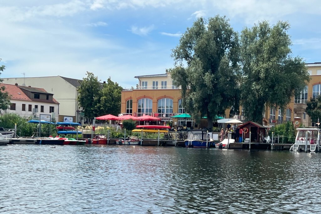 Blick auf den Steg der Bootsvermietung Krüger und Till in der Innenstadt von Werder (Havel). Im Hintergrund die Alte Brauerei.