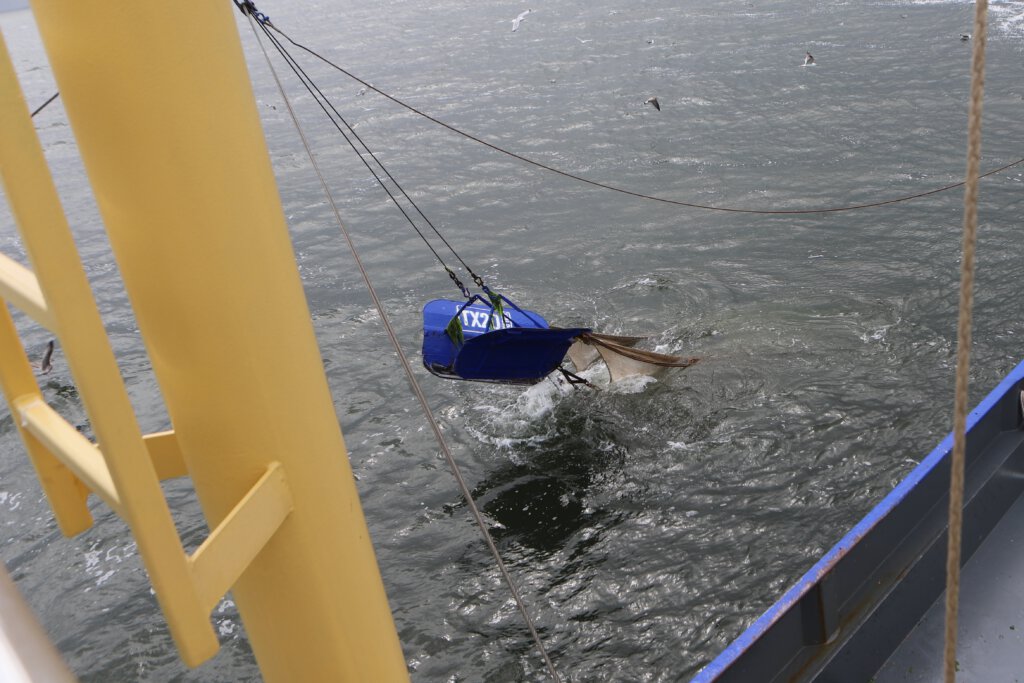 Die Netze eines Fischkutters versinken im Wasser